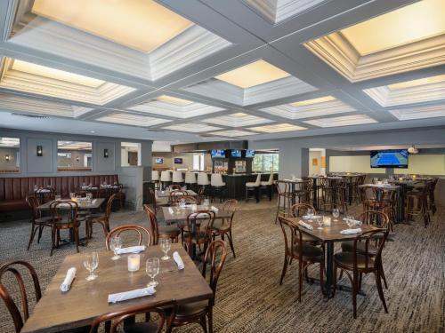 a dining room with wooden tables and chairs at DoubleTree by Hilton Portland, ME in South Portland