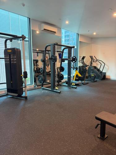 a gym with several tread machines in a room at Balcony, Free Parking, Workspace, Shared Pool & Gym in Melbourne