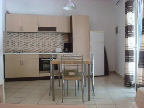 a kitchen with a table and chairs in a room at Smaragdi Studios and Rooms in Agios Kirykos