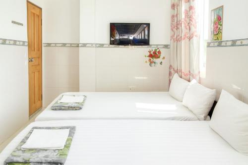 una habitación de hotel con dos camas y un televisor en Cường Phú Hotel Hồ Chí Minh, en Ho Chi Minh