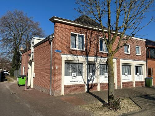 a red brick building with a tree in front of it at Pension Moerdijk in Moerdijk