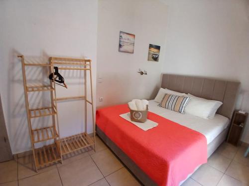 a bedroom with a bed with a red blanket and a ladder at Smaragdi Studios and Rooms in Agios Kirykos