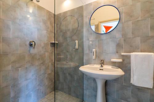 un baño con lavabo y espejo en Meet Hostel Cervia, en Cervia