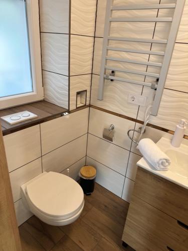 ein kleines Badezimmer mit Toilette und Waschbecken in der Unterkunft Napfény Apartman in Marcali