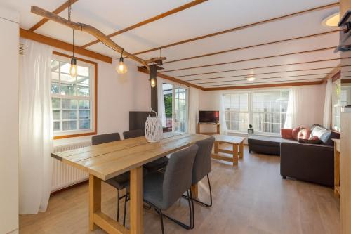 une salle à manger avec une table et un salon dans l'établissement chalet, à Putten