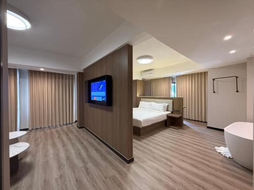 a hotel room with a bed and a tv and a tub at Star Hotel Pattaya in Pattaya