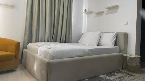 a bed with white sheets and pillows in a room at Lakowe Lakes Apartment, 2 Bedrooms in Ajibade