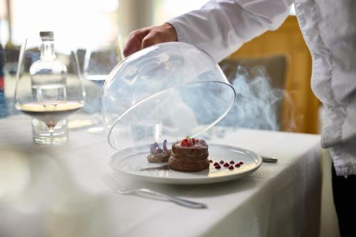 a person holding a plate with a piece of cake on a table at Hanusel Hof Wellness & Genuss in Panoramalage in Hellengerst