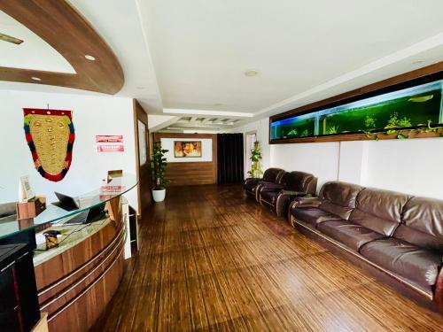 ein Wohnzimmer mit einem Ledersofa und einem Aquarium in der Unterkunft Oval Retreat in Kochi