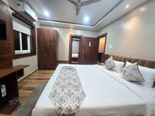 a bedroom with a large bed with white sheets at Pratima Heritage in Bhubaneshwar