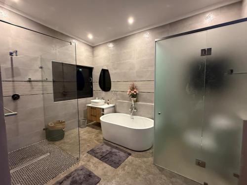 a bathroom with a tub and a sink and a shower at Blessed Lodge at Ingilozi Mabalingwe in Warmbaths
