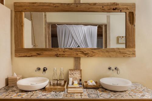 a bathroom with two sinks and a mirror at Seven Dreams A Pramana Experience in Nusa Penida