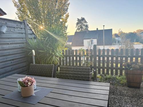 une table en bois avec une plante sur une terrasse dans l'établissement Where Business and Relaxation meet, à Heerserheide