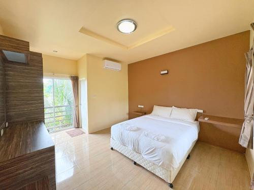 une chambre avec un lit blanc et une fenêtre dans l'établissement Krabi Ava Hill, à Krabi
