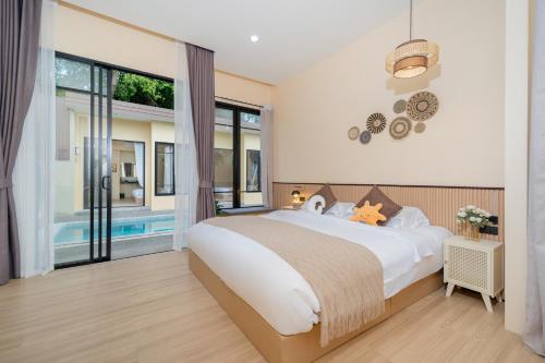 a bedroom with a large bed and a pool at Amaleena Pool Access Suites in Ban Bang Chak