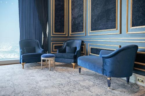 a room with three blue chairs and a table at The Bentley Luxury Hotel & Suites in Doha