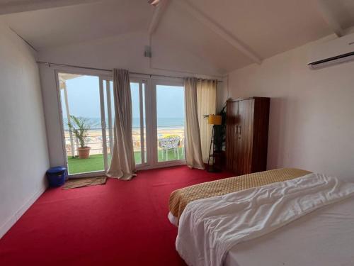 a hotel room with two beds and a large window at Casa fiesta patnem in Patnem