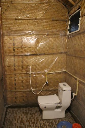 a small bathroom with a toilet in a room at Rocky Meadows Resort Hampi in Hampi