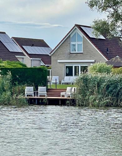 a house on a dock on a body of water at Fero Breskens - Modern & kindvriendelijk vakantiehuis op wandelafstand van het strand in Breskens