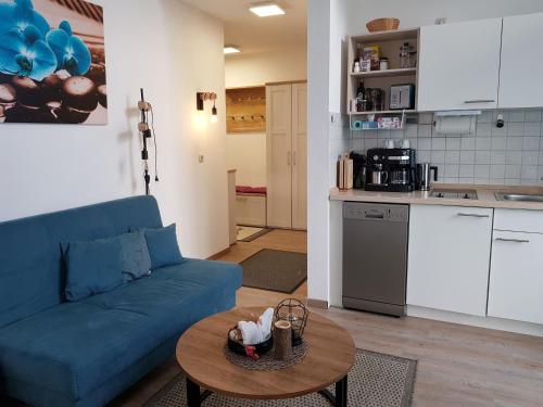 a living room with a blue couch and a table at Charmante Wohnung In Langfurth Mit Kleinem Balkon in Schöfweg