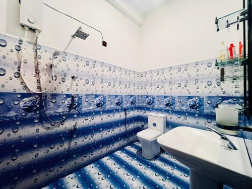 a blue and white bathroom with a toilet and a sink at Meadow View Villa in Dickwella