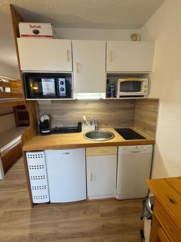 een kleine keuken met een gootsteen en een magnetron bij Studio RISOUL station in Risoul