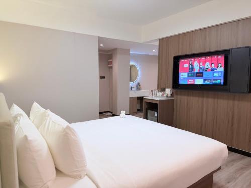 una camera d'albergo con un letto e una TV a schermo piatto di Star Hotel Pattaya a Centro di Pattaya