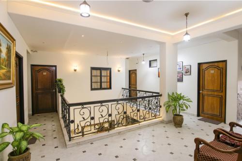 a room with a balcony with plants and wooden doors at Via Singh Suite in Gurgaon