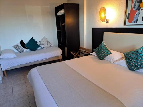 a hotel room with two beds in a room at Hôtel Le Collier in Antibes