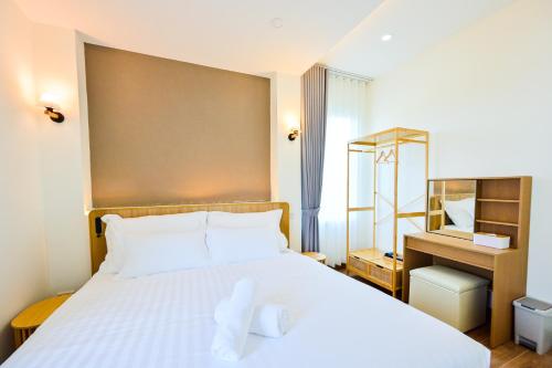 a bedroom with a white bed and a mirror at Santara Pool Villa Udon in Udon Thani
