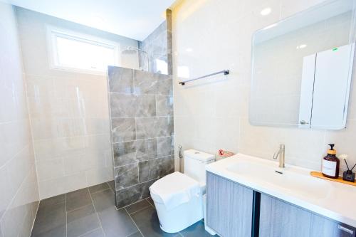 a bathroom with a toilet and a sink and a mirror at Santara Pool Villa Udon in Udon Thani