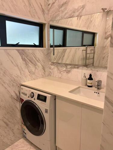 a kitchen with a washing machine and a sink at Almorah 2 bedroom in Auckland