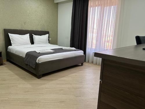 a bedroom with a bed with a dresser and a desk at Aparan Hotel in Aparan