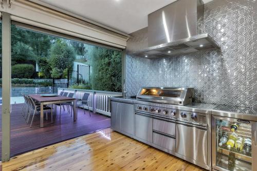 a kitchen with a stove and a table on a deck at Luxury Resort Studio Apartment Retreat with Pool, Tennis & Alfresco