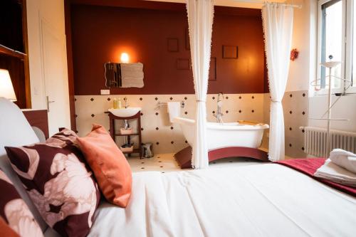 ein Badezimmer mit einem Bett und einer Badewanne in einem Zimmer in der Unterkunft Le Madeleine - Central - Elegant - Cozy - By Primo in Caen