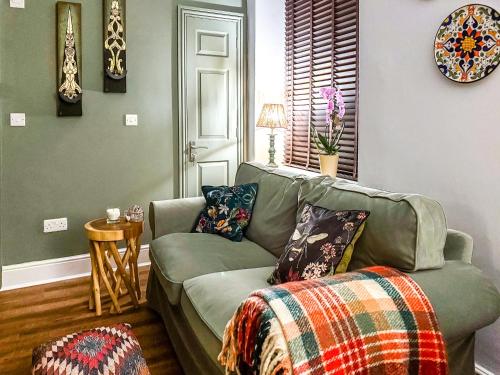 a living room with a green couch with pillows at Novena - Uk50586 in Penrith
