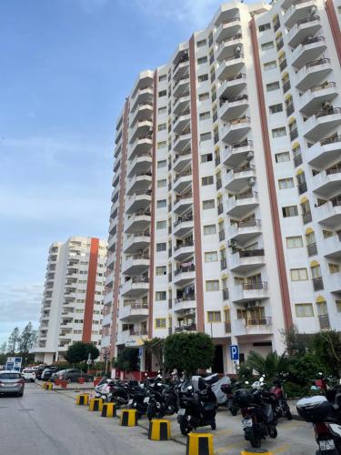 ein großes Wohnhaus mit auf einem Parkplatz abgestellten Motorrädern in der Unterkunft Apartamento Maria do Céu in Portimão
