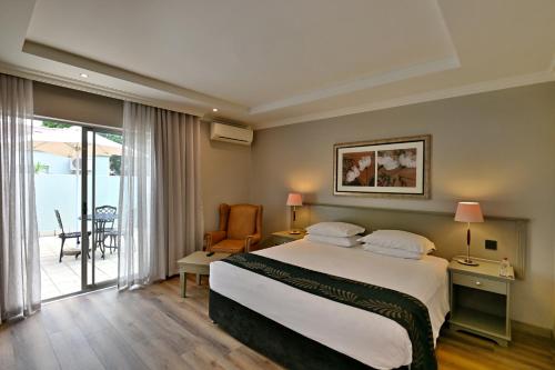 ein Hotelzimmer mit Bett und Balkon in der Unterkunft Courtyard Hotel Sandton in Johannesburg