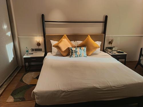 ein Schlafzimmer mit einem großen Bett und Kissen in der Unterkunft Romance Resort Varkala in Varkala