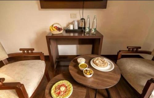 a living room with a table with plates of food on it at Hotel Rosewood-Near Delhi Airport-Free Airport Drop in New Delhi