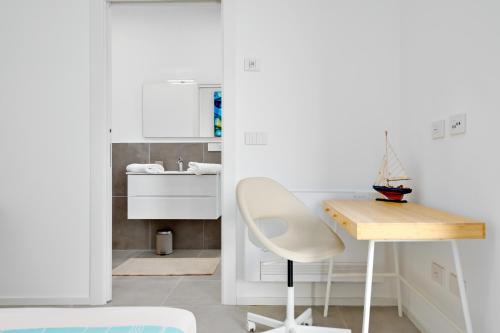 een witte keuken met een bureau en een stoel bij Villa Mathis - by And service in Casa Tamponi