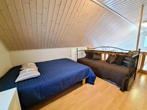 a bedroom with two beds in a attic at Aamuaurinko in Korospohja