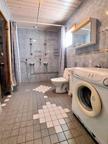 a bathroom with a washing machine and a toilet at Aamuaurinko in Korospohja