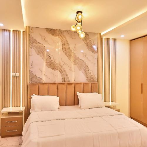 una camera da letto con un letto e un dipinto sul muro di Purple Lavender Court a Ikoyi