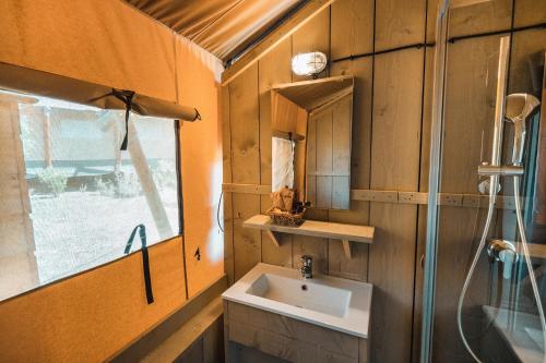 ein Badezimmer mit Waschbecken und Fenster in der Unterkunft Glamping Le Tegole in Riparbella