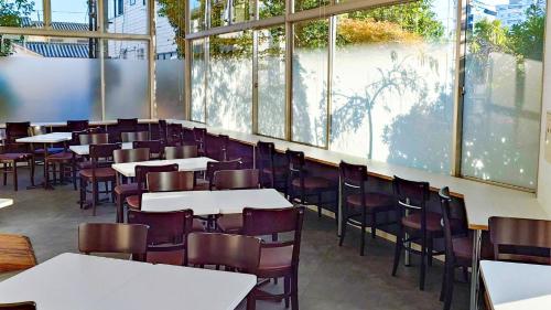 a dining room with tables and chairs and windows at ホテルテラス小名浜 in Iwaki