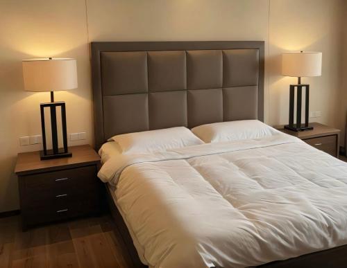 a bedroom with a large white bed with two lamps at Mini suite in House or Varz hotel boutique in Tijuana