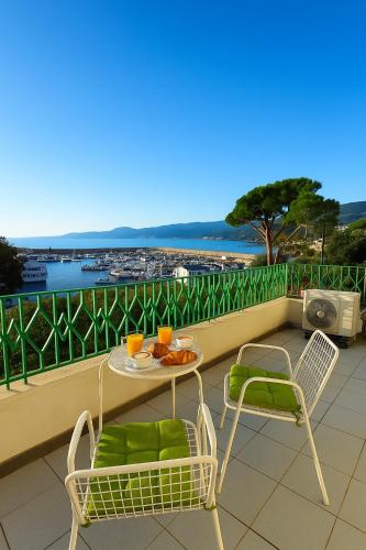 a table and chairs on a balcony with a view of the ocean at Liberty Seaview Apartment Cala Gonone in Cala Gonone