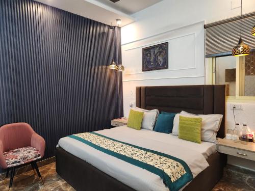 a bedroom with a large bed and a chair at Ganga Riverfront Rishikesh in Rishīkesh