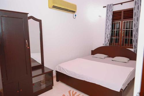 ein kleines Schlafzimmer mit einem Bett und einer Kommode in der Unterkunft Peacock Hill Villa in Matugama